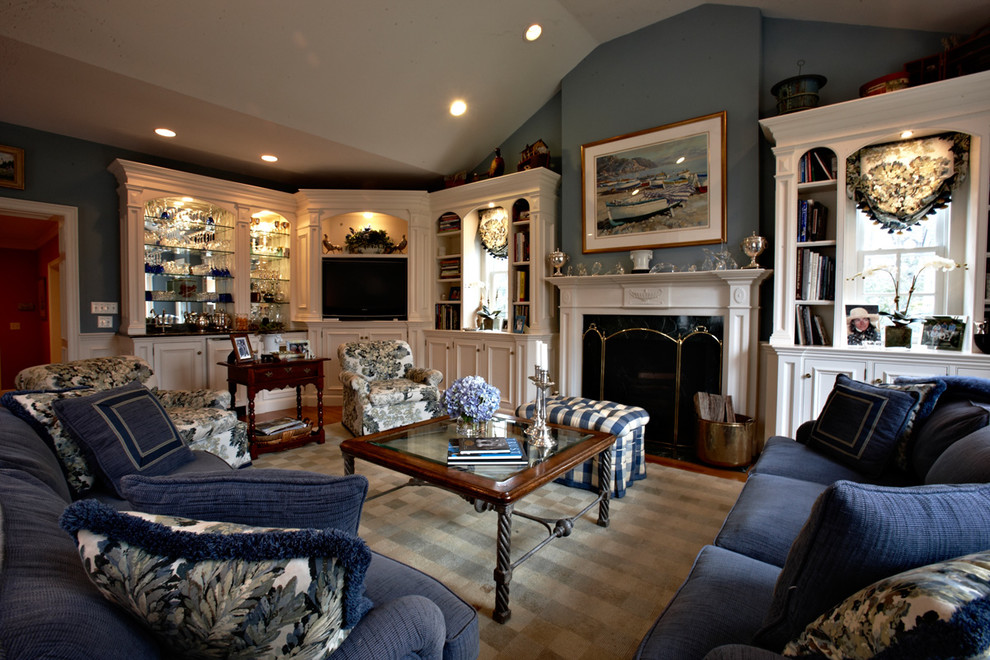 Modelo de sala de estar con barra de bar abierta tradicional de tamaño medio con paredes azules, suelo de madera en tonos medios, todas las chimeneas, marco de chimenea de madera, pared multimedia y suelo marrón