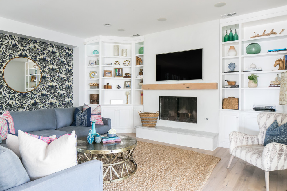 Maritimes Wohnzimmer mit weißer Wandfarbe, hellem Holzboden, Kamin und beigem Boden in Orange County