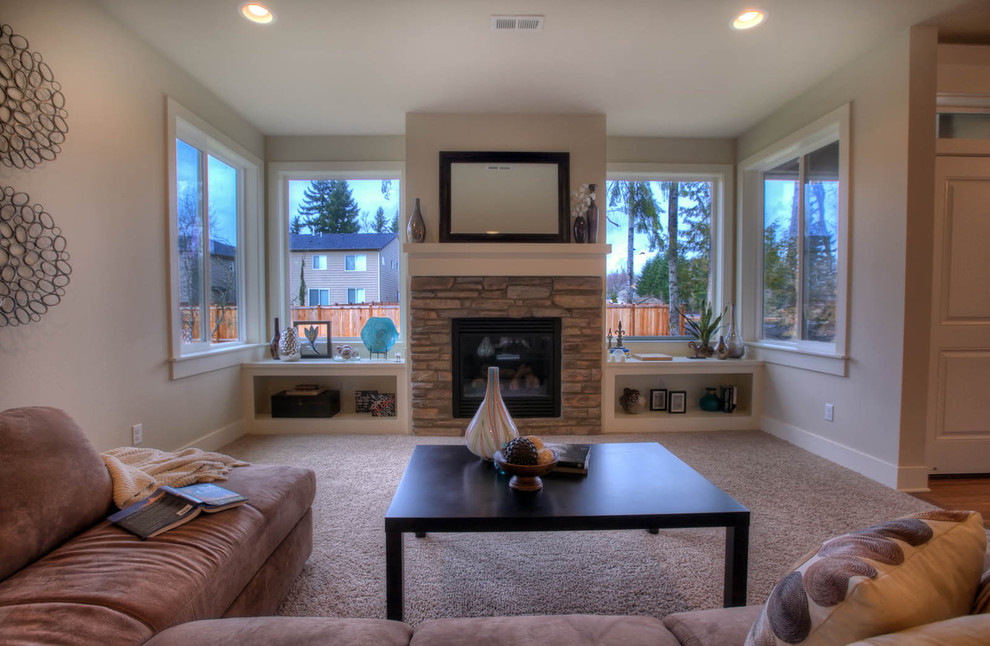 This is an example of a contemporary games room in Seattle with beige walls, carpet, a standard fireplace, a stone fireplace surround and beige floors.