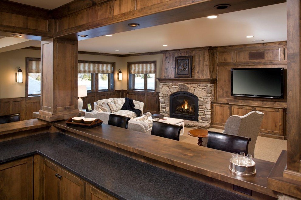 Rustic games room in Minneapolis with a stone fireplace surround.