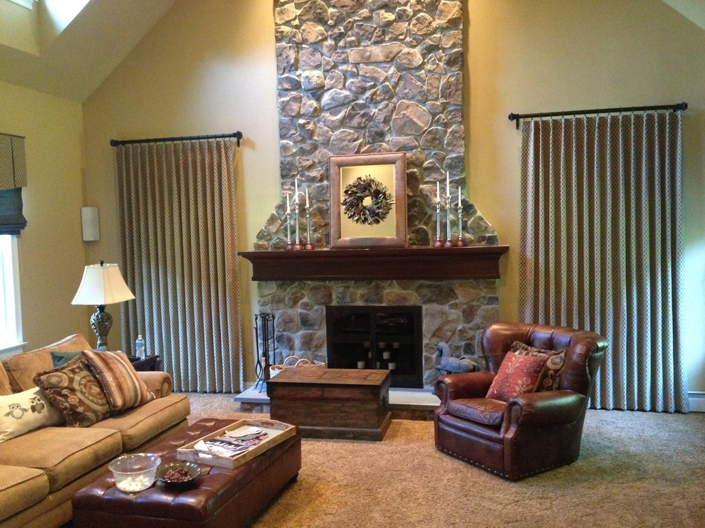 Ejemplo de sala de estar cerrada tradicional grande con paredes beige, moqueta, todas las chimeneas, marco de chimenea de piedra, pared multimedia y suelo beige
