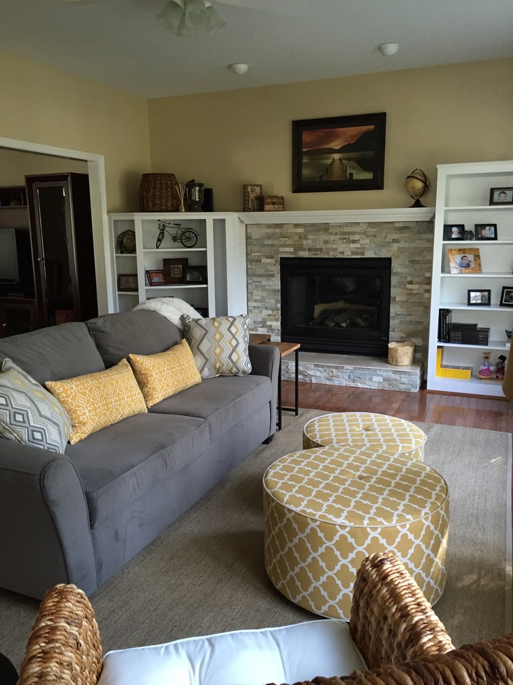 Ejemplo de sala de estar abierta clásica renovada grande sin televisor con paredes amarillas, suelo de madera en tonos medios, todas las chimeneas y marco de chimenea de piedra