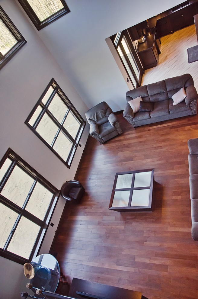 Large elegant open concept medium tone wood floor and brown floor family room photo in Other with white walls