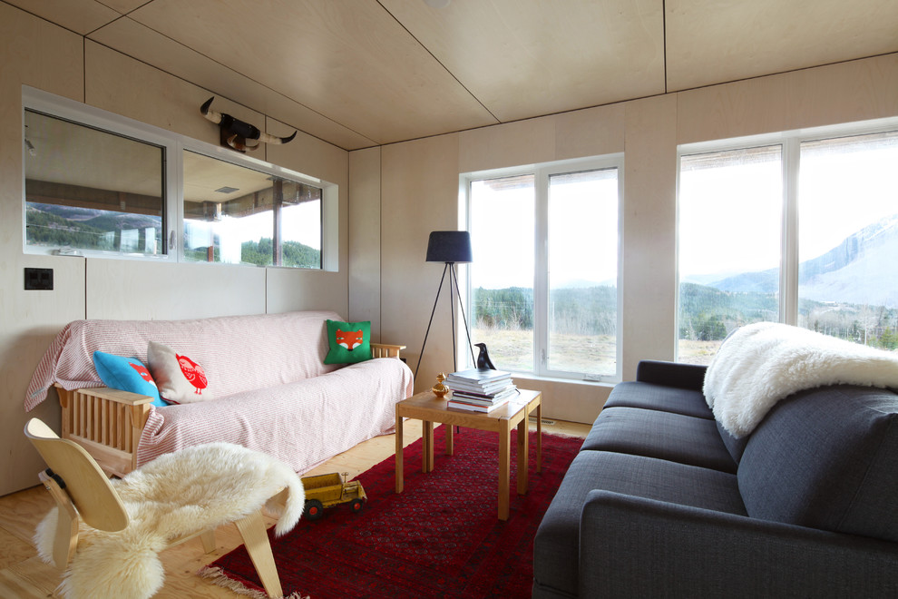 Cette photo montre une salle de séjour tendance avec un mur beige, un sol en contreplaqué et aucun téléviseur.