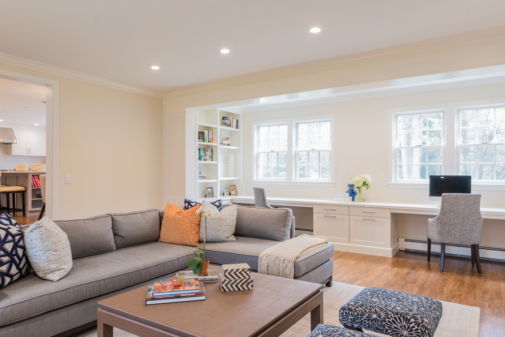 Mittelgroßes Klassisches Wohnzimmer mit gelber Wandfarbe, braunem Holzboden, braunem Boden, Kamin, TV-Wand und Kaminumrandung aus Stein in Boston