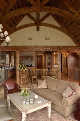 Réalisation d'une très grande salle de séjour tradition ouverte avec un mur beige, parquet clair, une cheminée standard et un manteau de cheminée en pierre.