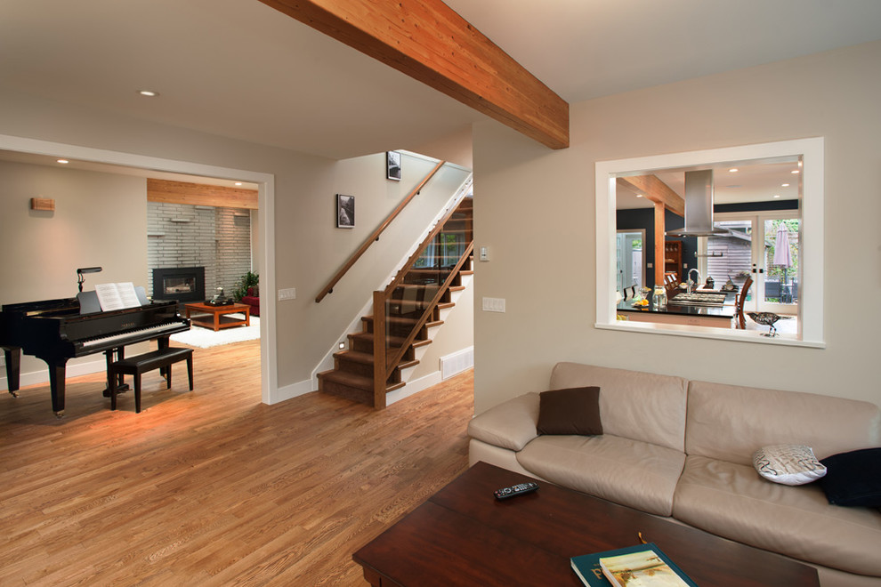 Esempio di un soggiorno minimal di medie dimensioni e aperto con pareti beige e pavimento in legno massello medio