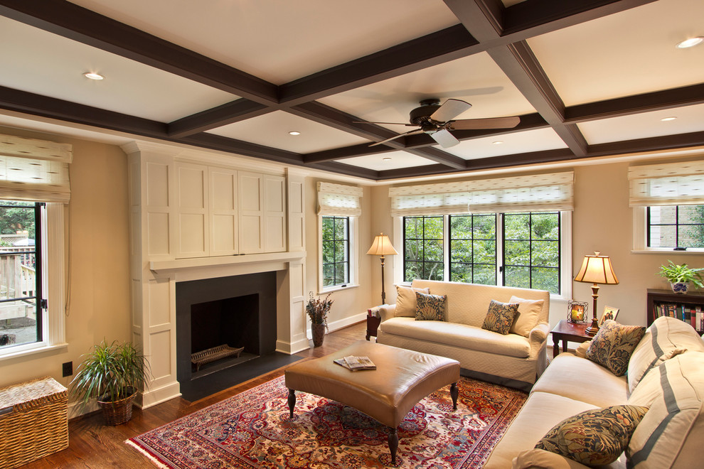 Diseño de sala de estar tradicional con paredes beige, suelo de madera oscura, todas las chimeneas y televisor retractable