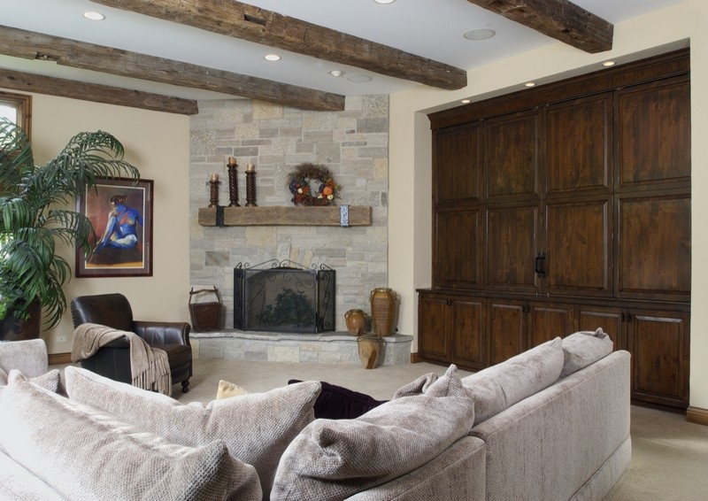 Inspiration for a huge timeless carpeted family room remodel in Chicago with beige walls, a standard fireplace, a stone fireplace and a media wall