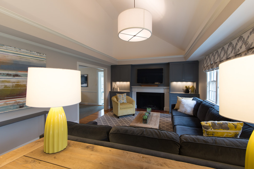Mittelgroßes Klassisches Wohnzimmer mit grauer Wandfarbe, braunem Holzboden, Kaminumrandung aus Backstein und Multimediawand in Boston