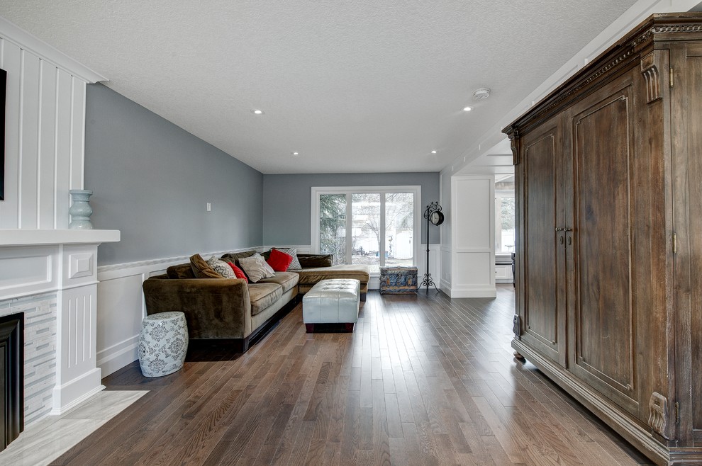 Inspiration for a medium sized traditional open plan games room in Calgary with a music area, grey walls, medium hardwood flooring, a standard fireplace, a tiled fireplace surround, no tv and brown floors.