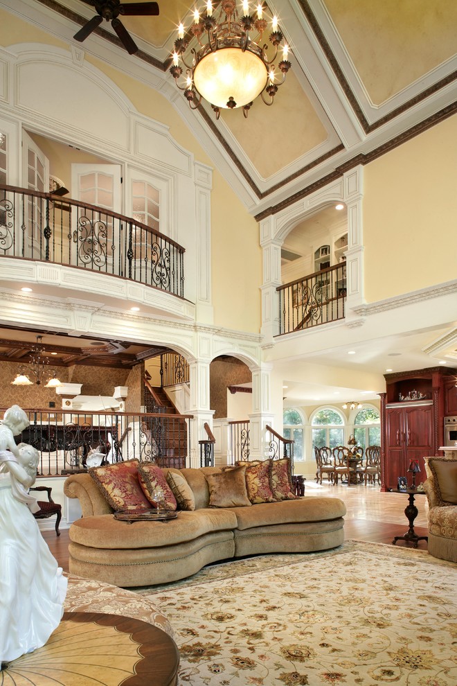 Foto di un grande soggiorno tradizionale aperto con pareti beige, pavimento in legno massello medio e parete attrezzata