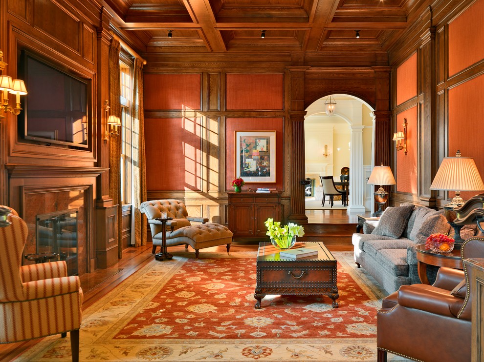 На фото: изолированная гостиная комната:: освещение в классическом стиле с оранжевыми стенами, паркетным полом среднего тона, стандартным камином и телевизором на стене