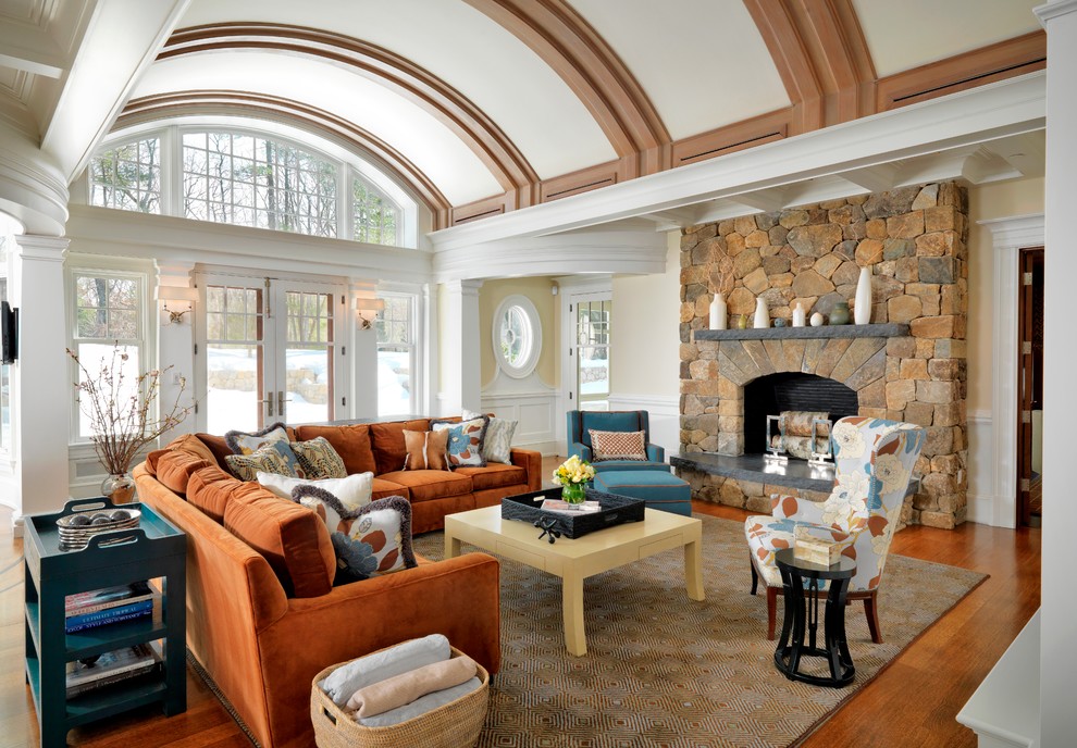 Fernseherloses Klassisches Wohnzimmer mit beiger Wandfarbe, braunem Holzboden, Kamin und Kaminumrandung aus Stein in Boston