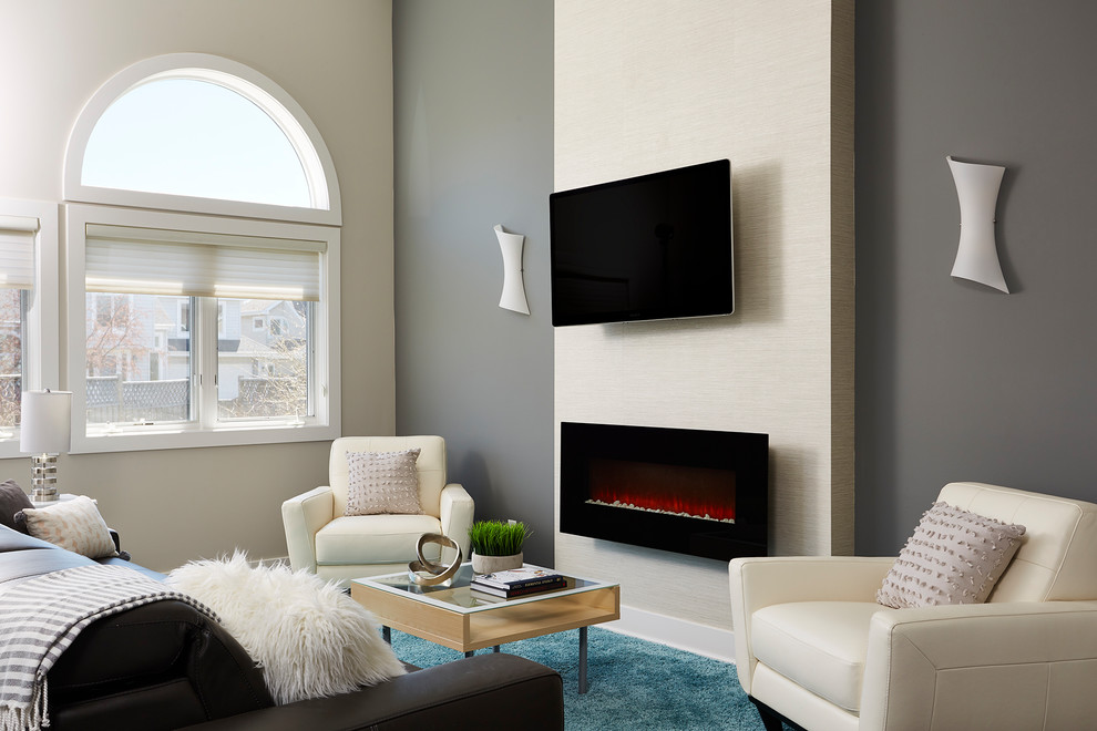 Modern inredning av ett mellanstort allrum med öppen planlösning, med grå väggar, laminatgolv, en hängande öppen spis, en väggmonterad TV och brunt golv