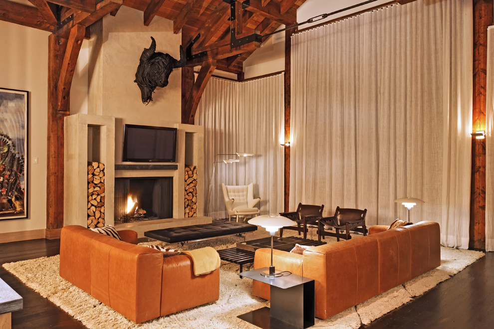 Exemple d'une salle de séjour montagne ouverte avec un mur beige, parquet foncé, une cheminée standard et un téléviseur fixé au mur.