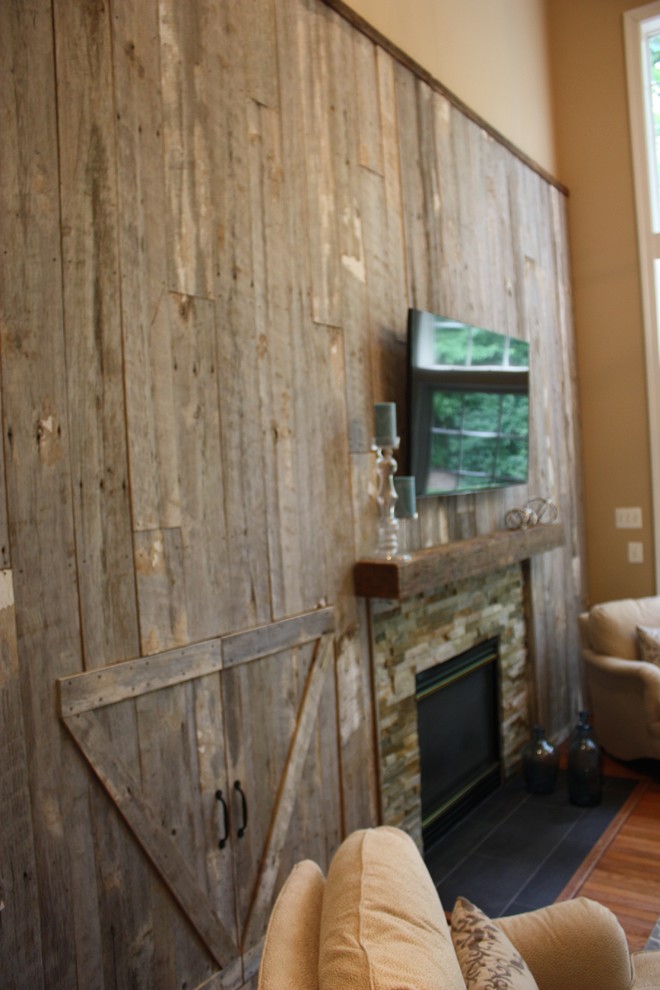Diseño de sala de estar abierta campestre de tamaño medio con paredes beige, suelo de madera en tonos medios, todas las chimeneas, marco de chimenea de piedra y televisor colgado en la pared
