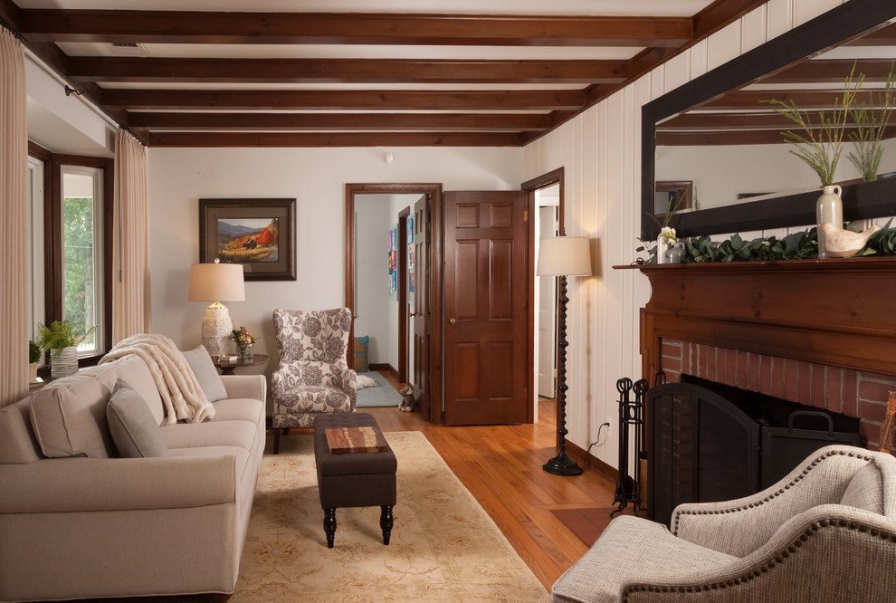 Пример оригинального дизайна: маленькая изолированная гостиная комната в стиле кантри с паркетным полом среднего тона, стандартным камином, фасадом камина из кирпича, коричневым полом и белыми стенами для на участке и в саду