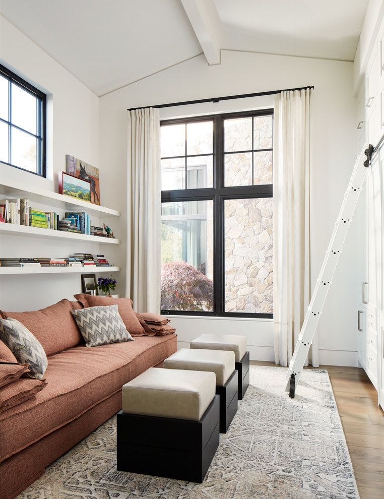 Foto de sala de estar con biblioteca de estilo de casa de campo sin chimenea con paredes blancas y suelo de madera en tonos medios