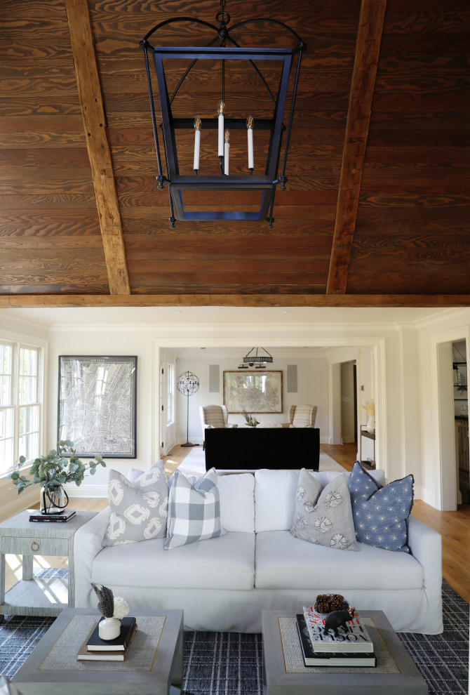 Exemple d'une grande salle de séjour nature ouverte avec un mur blanc, parquet clair, un manteau de cheminée en pierre, un sol marron et un plafond en bois.