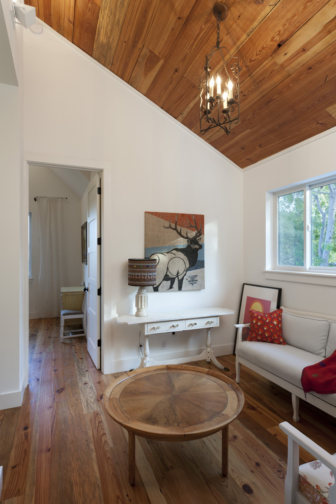 Farmhouse medium tone wood floor family room photo in Austin with white walls