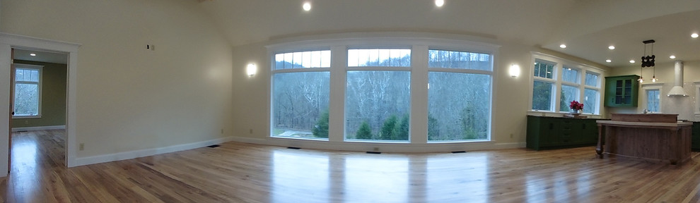 Foto de sala de estar de estilo de casa de campo de tamaño medio con paredes beige, suelo de madera clara y televisor colgado en la pared