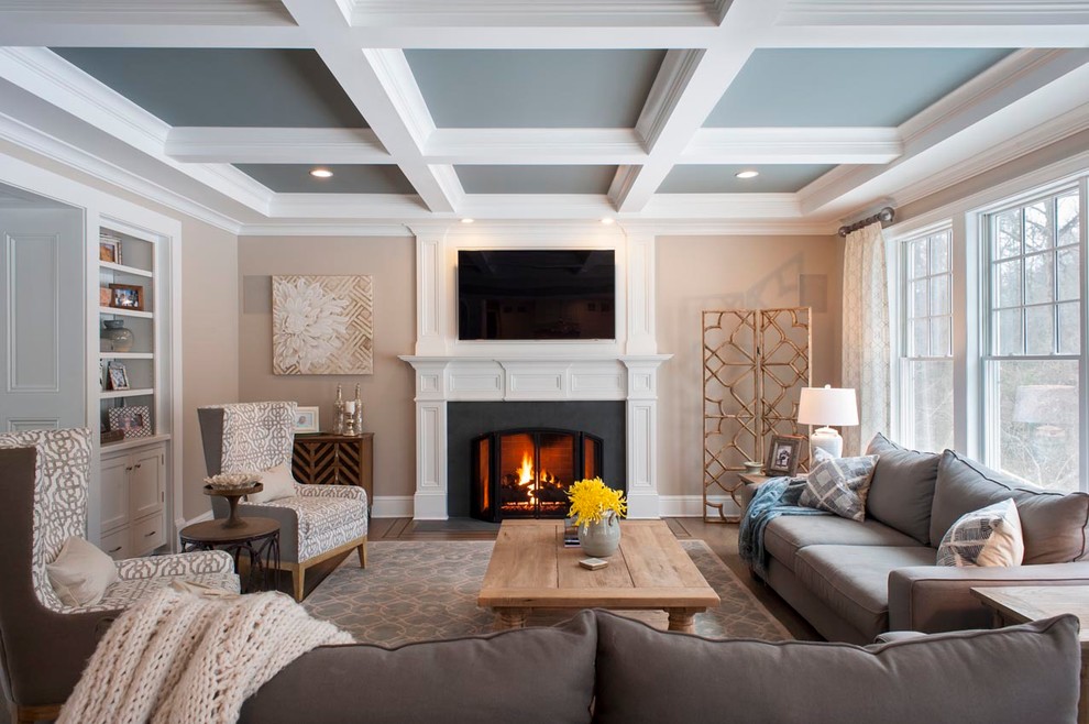 Идея дизайна: большая открытая гостиная комната в стиле неоклассика (современная классика) с бежевыми стенами, темным паркетным полом, стандартным камином, телевизором на стене, фасадом камина из дерева и ковром на полу