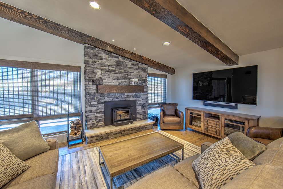 Foto di un soggiorno contemporaneo di medie dimensioni e aperto con pareti grigie, parquet chiaro, stufa a legna, cornice del camino in pietra e TV a parete