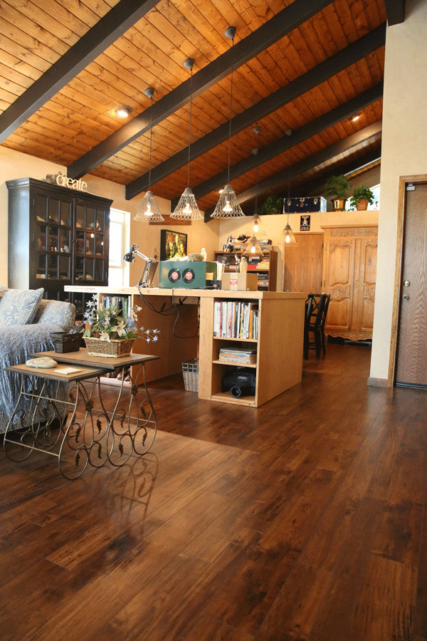 Esempio di un soggiorno stile rurale con pavimento in laminato e pavimento marrone