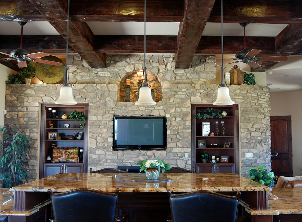 Example of a large tuscan open concept family room design in Phoenix with a media wall