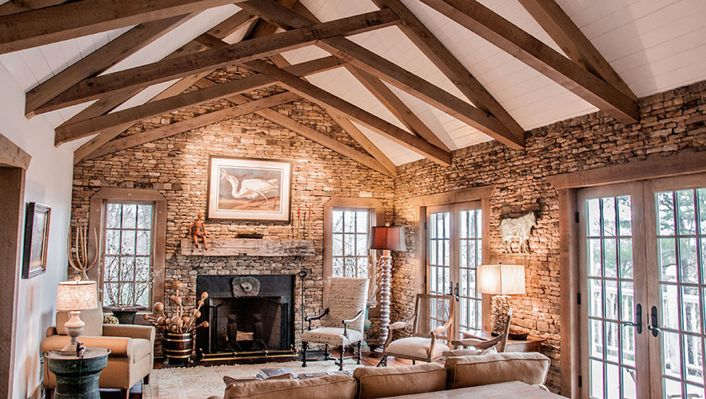 Ejemplo de sala de estar tipo loft clásica grande con paredes beige, suelo de madera en tonos medios, todas las chimeneas y marco de chimenea de piedra