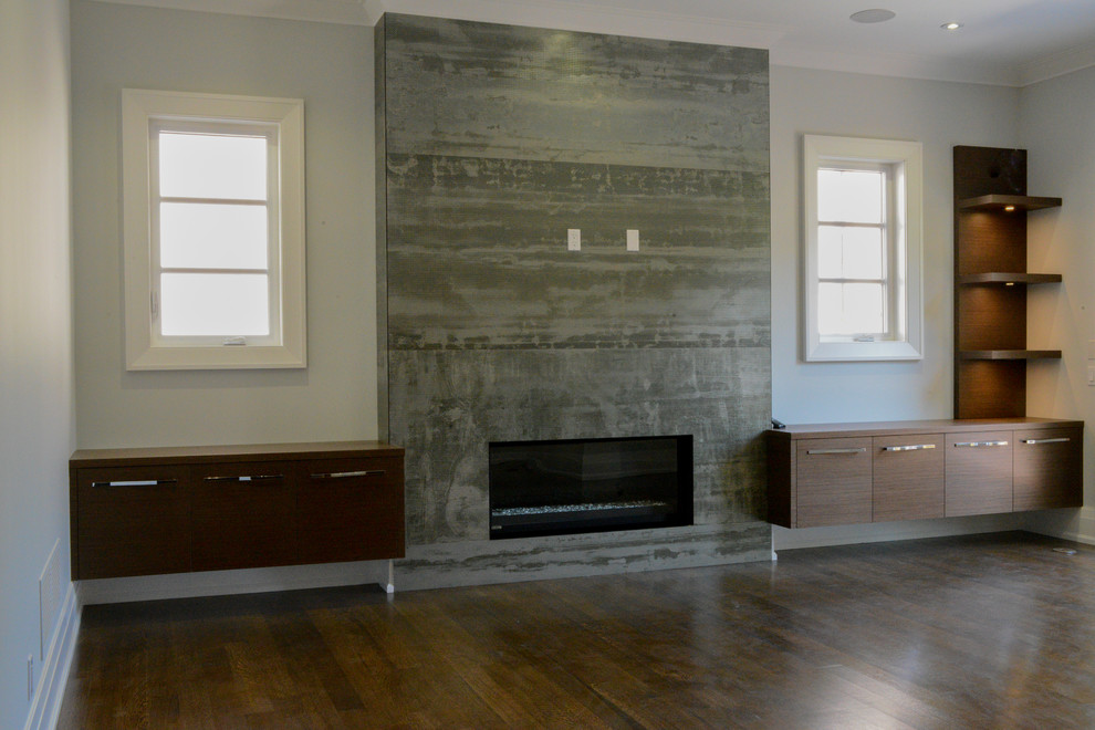 На фото: открытая гостиная комната среднего размера в стиле модернизм с темным паркетным полом, стандартным камином, фасадом камина из камня, телевизором на стене, синими стенами и коричневым полом с