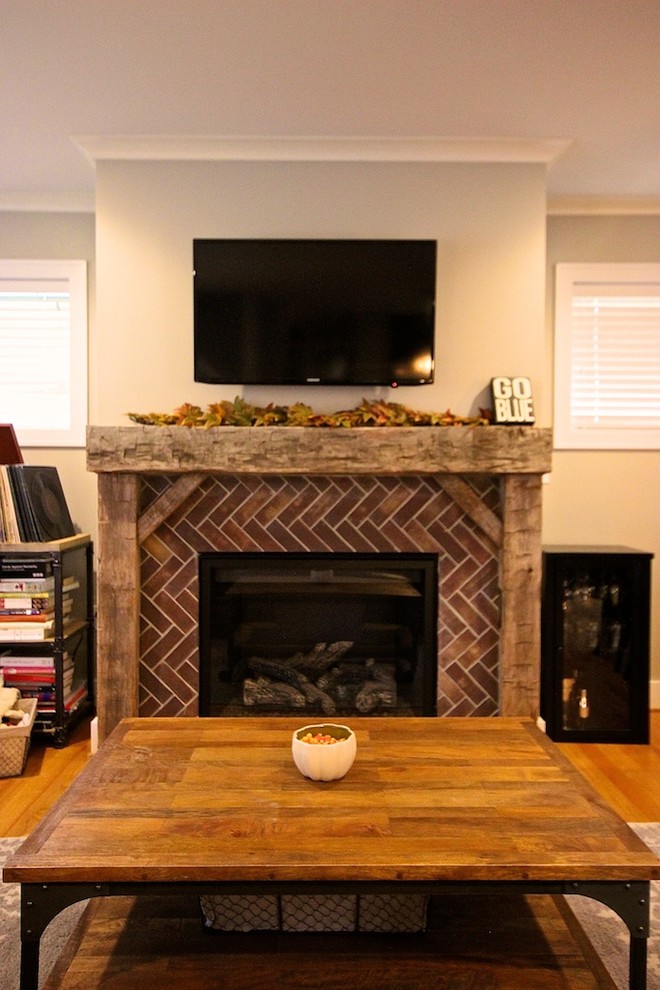 Photo of a medium sized traditional open plan games room in Detroit with grey walls, light hardwood flooring, a standard fireplace, a brick fireplace surround and a wall mounted tv.