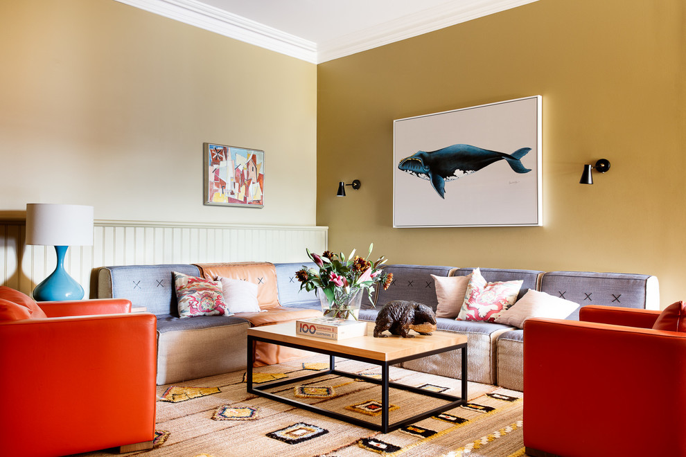 Diseño de sala de estar clásica renovada con paredes amarillas, suelo de madera en tonos medios y suelo marrón