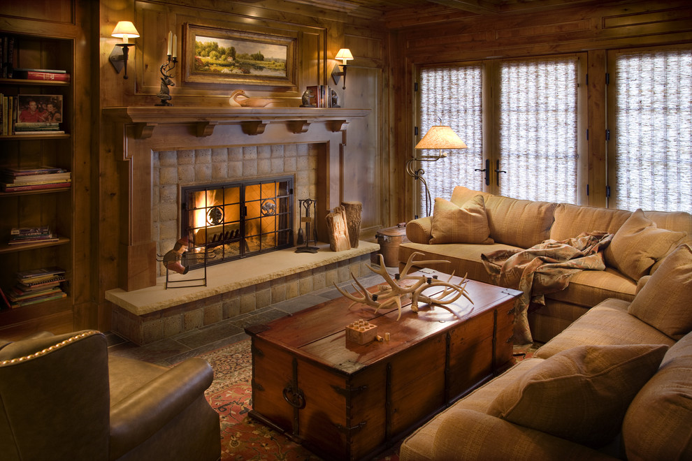 Cette image montre une salle de séjour traditionnelle avec un mur marron, une cheminée standard et un manteau de cheminée en pierre.