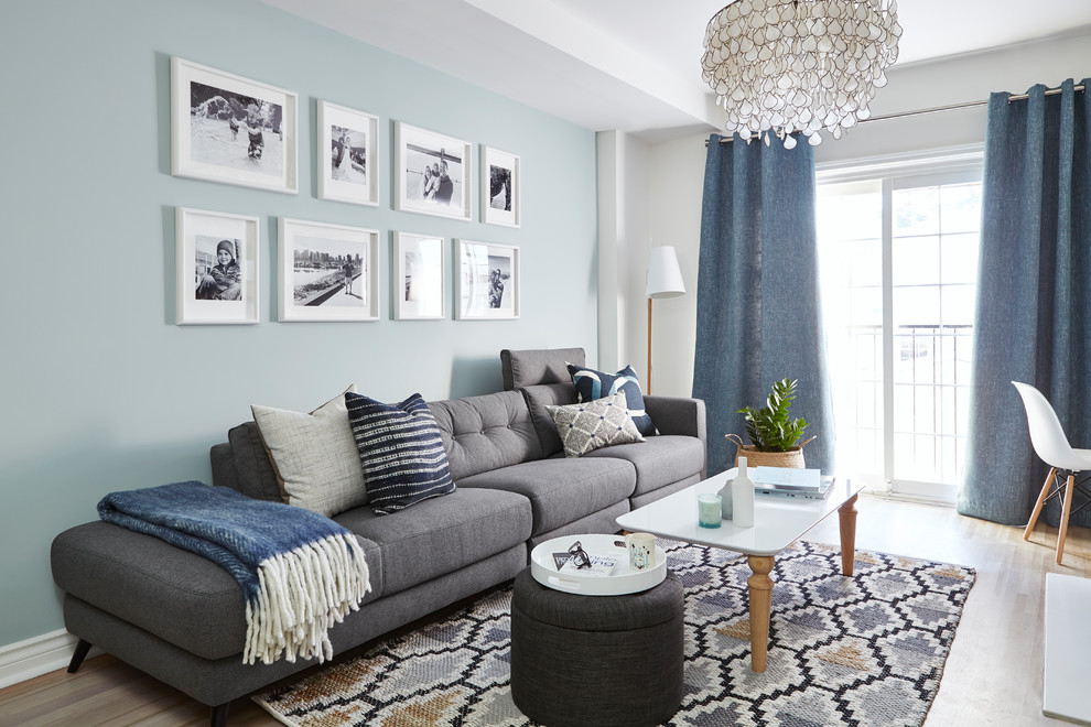 Maritimes Wohnzimmer mit blauer Wandfarbe, hellem Holzboden und beigem Boden in Toronto