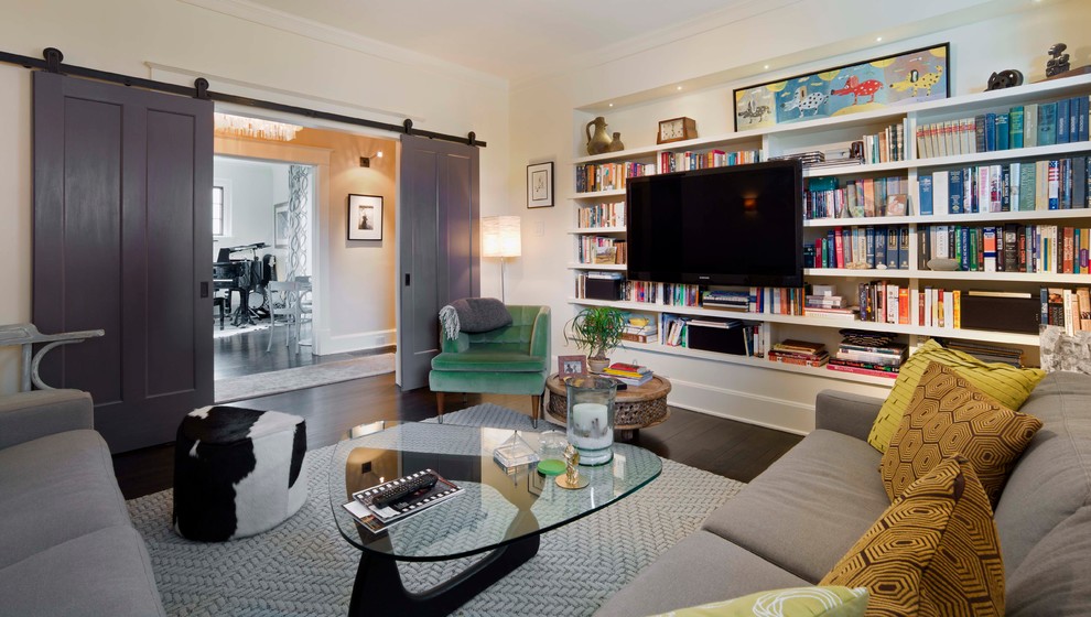 Стильный дизайн: изолированная гостиная комната в современном стиле с бежевыми стенами, темным паркетным полом, телевизором на стене и ковром на полу без камина - последний тренд