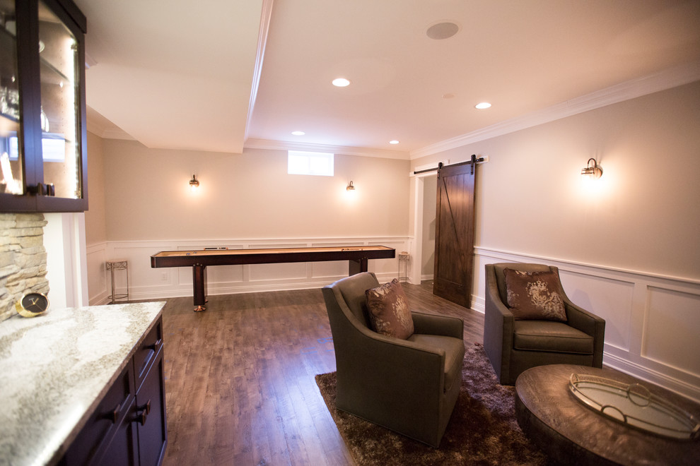 Large classic open plan games room in Chicago with vinyl flooring, a game room, beige walls, no fireplace, a built-in media unit, brown floors and a dado rail.