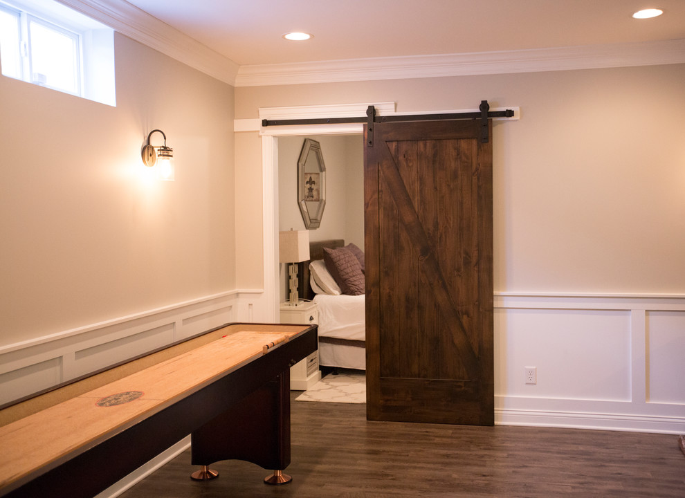 This is an example of a large classic open plan games room in Chicago with vinyl flooring, a game room, beige walls, no fireplace, a built-in media unit, brown floors and a dado rail.