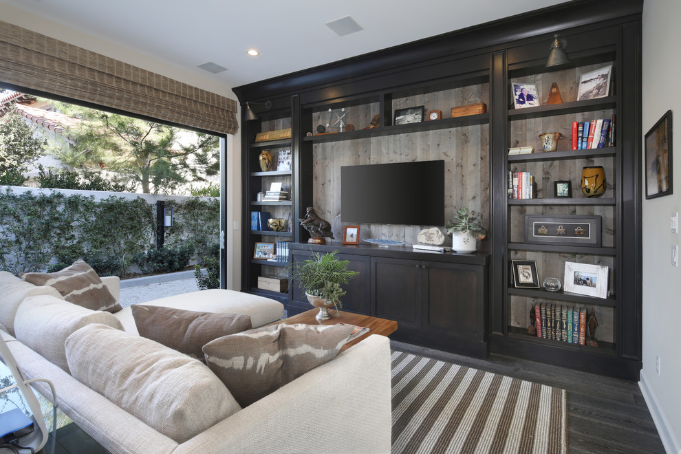 Abgetrenntes Mediterranes Wohnzimmer mit weißer Wandfarbe, dunklem Holzboden, TV-Wand und grauem Boden in Orange County