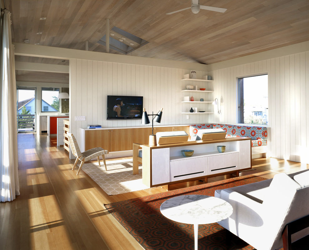 Foto di un soggiorno stile marino con pareti bianche, pavimento in legno massello medio e TV a parete