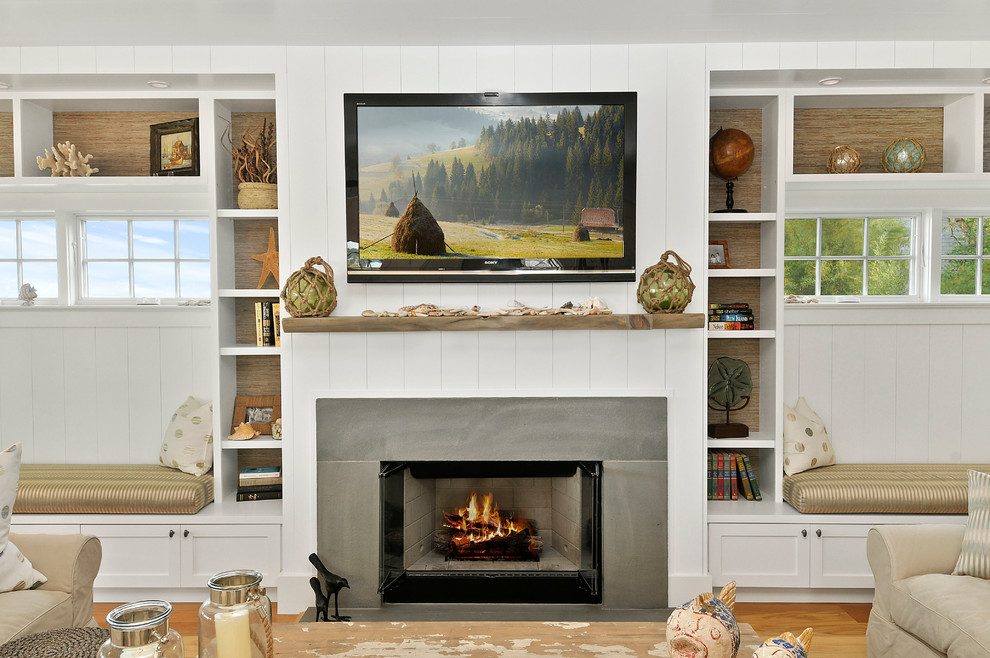 Imagen de sala de estar abierta marinera de tamaño medio con paredes blancas, suelo de madera clara, todas las chimeneas y televisor colgado en la pared