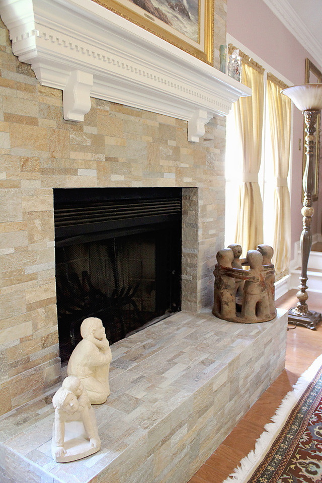Idée de décoration pour une grande salle de séjour tradition ouverte avec un mur beige, parquet foncé, une cheminée standard et un manteau de cheminée en pierre.