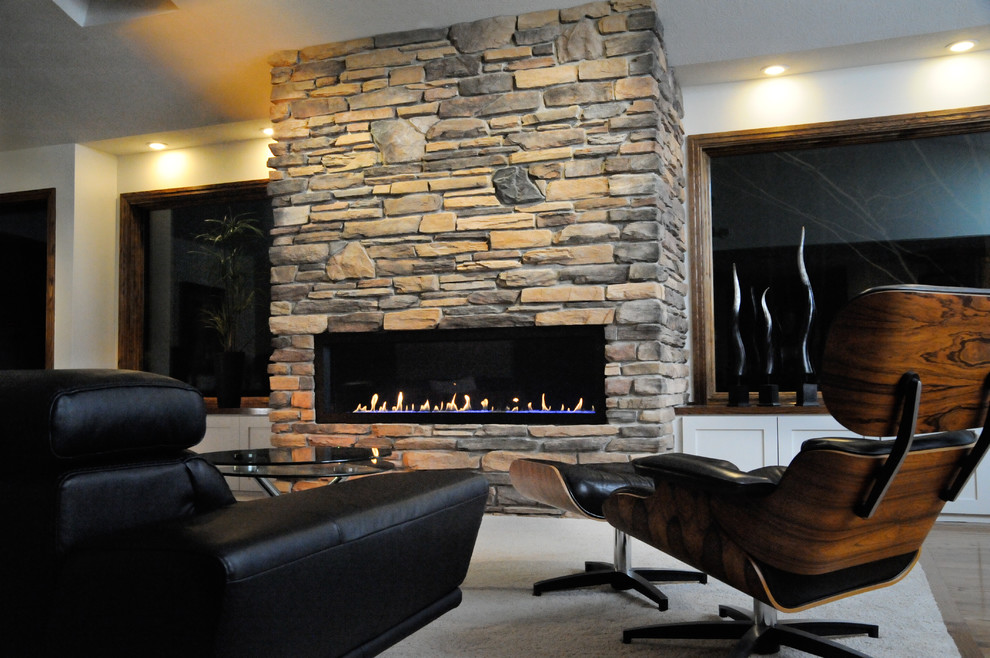 クリーブランドにある高級な広いミッドセンチュリースタイルのおしゃれなオープンリビング (白い壁、セラミックタイルの床、標準型暖炉、石材の暖炉まわり、テレビなし、白い床) の写真