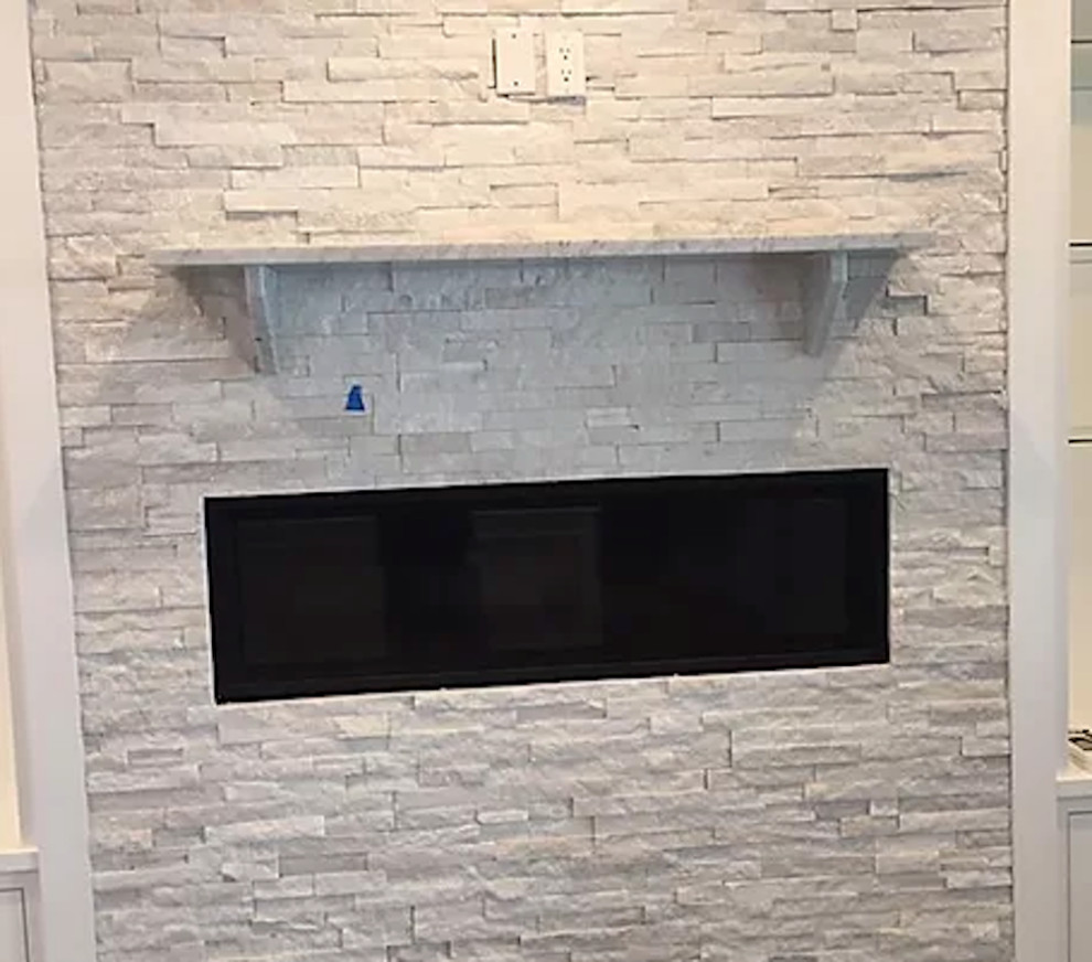 Inspiration for a contemporary games room in New York with a standard fireplace and a brick fireplace surround.