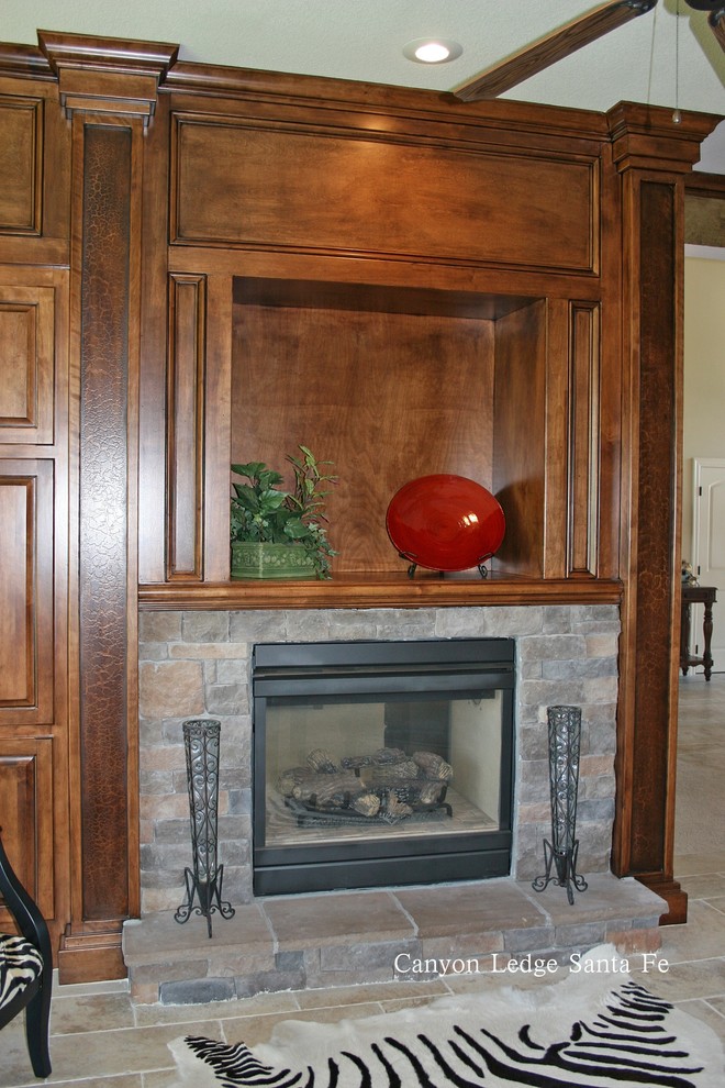トロントにある小さなトラディショナルスタイルのおしゃれなファミリールーム (ライブラリー、スレートの床、標準型暖炉、石材の暖炉まわり、テレビなし) の写真