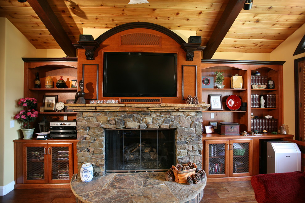 Large rustic open plan games room in Orange County with yellow walls, medium hardwood flooring, a standard fireplace, a stone fireplace surround and a built-in media unit.