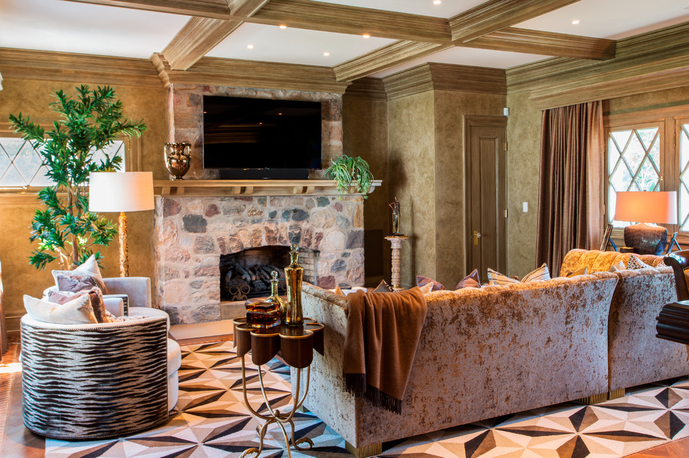 Aménagement d'une très grande salle de séjour classique ouverte avec un mur multicolore, un sol en bois brun, une cheminée standard, un manteau de cheminée en pierre et un téléviseur fixé au mur.