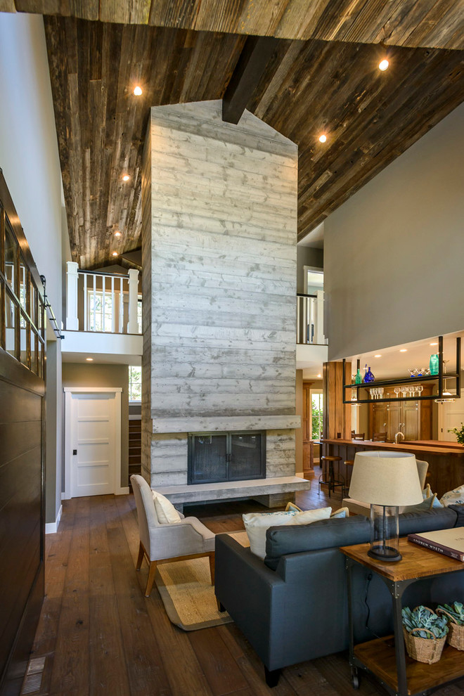 Rustikales Wohnzimmer mit grauer Wandfarbe, dunklem Holzboden, Kamin und Kaminumrandung aus Beton in San Diego
