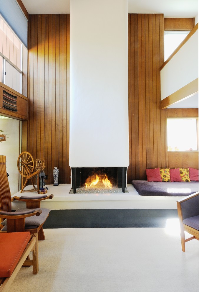 Esempio di un soggiorno minimalista con pareti marroni, camino classico e tappeto